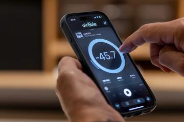 В руках людини смартфон, на екрані інтерефейс застосунку My Lyngdorf де зображено великий регулятор гучності