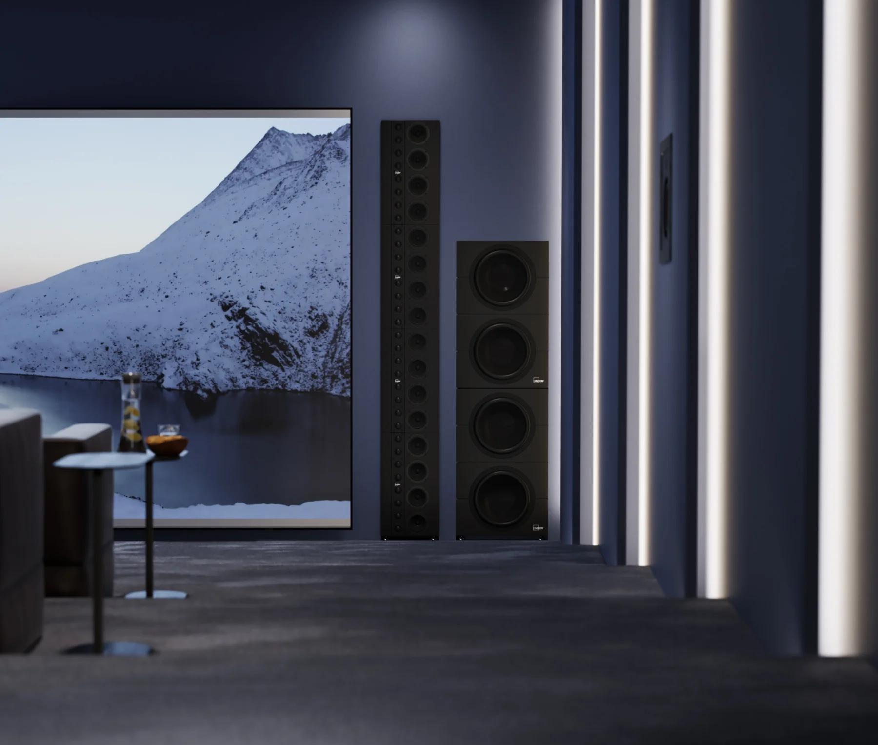 Part of a small cinema hall, with a linear array of Lyngdorf LS-1000 loudspeakers, BW-20 woofers, and a D-5 side loudspeaker built into the field of view, and a screen displaying images of mountains and water