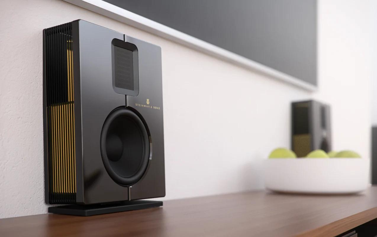 A pair of Model S-15 loudspeakers sits on the stand under the TV