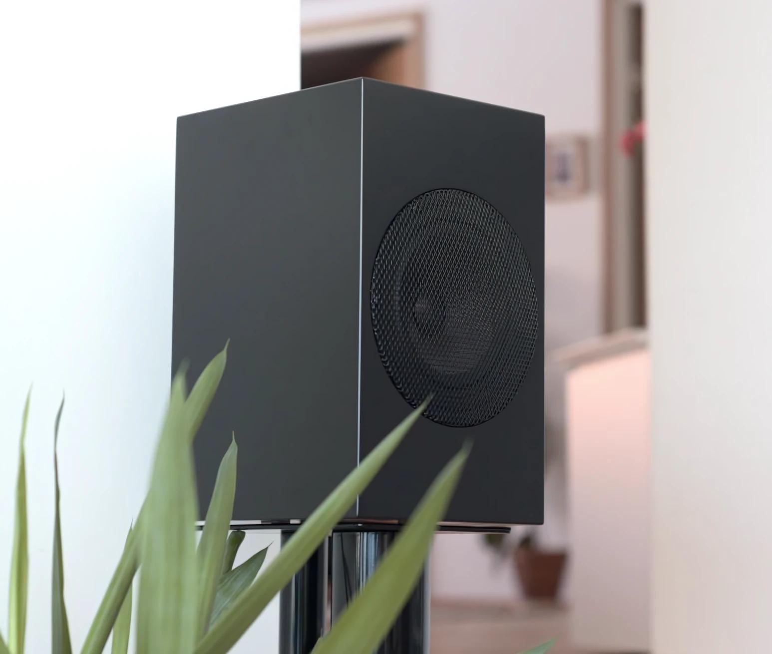 Гучномовець Gradient BS-1 у повністю чорному кольорі розміщений вертикально на підставці неподалік від стіни